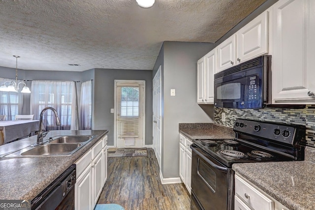 kitchen with black appliances, sink, dark hardwood / wood-style flooring, white cabinetry, and a chandelier