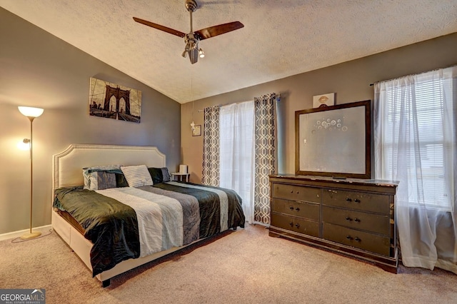 bedroom with a textured ceiling, multiple windows, ceiling fan, and vaulted ceiling