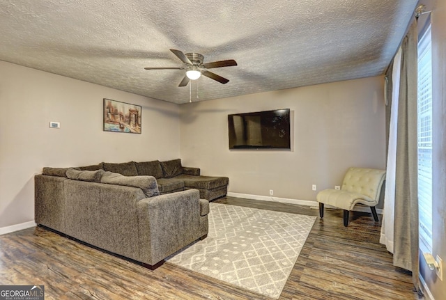 living room with a textured ceiling, hardwood / wood-style flooring, and ceiling fan