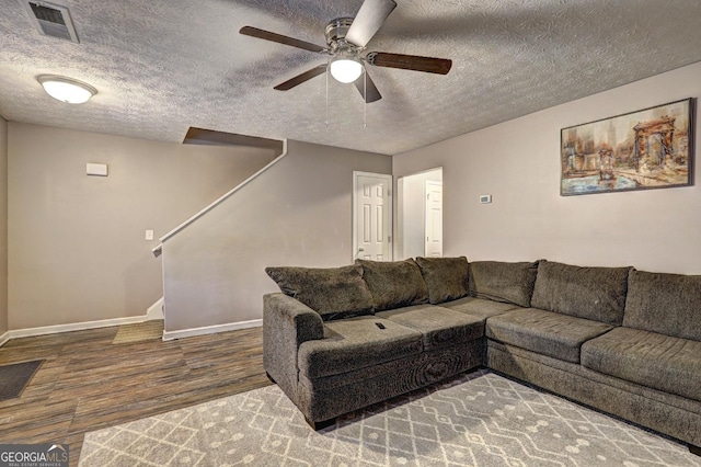 living room featuring a textured ceiling, hardwood / wood-style flooring, and ceiling fan