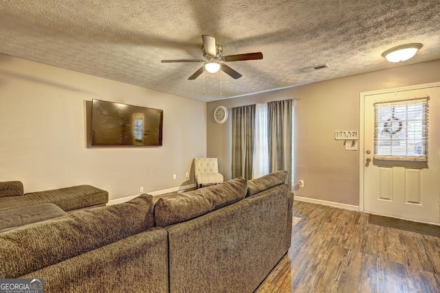 living room with hardwood / wood-style floors, a textured ceiling, and ceiling fan