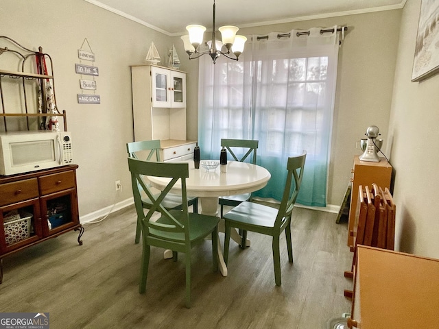 dining room with crown molding, hardwood / wood-style floors, and a chandelier