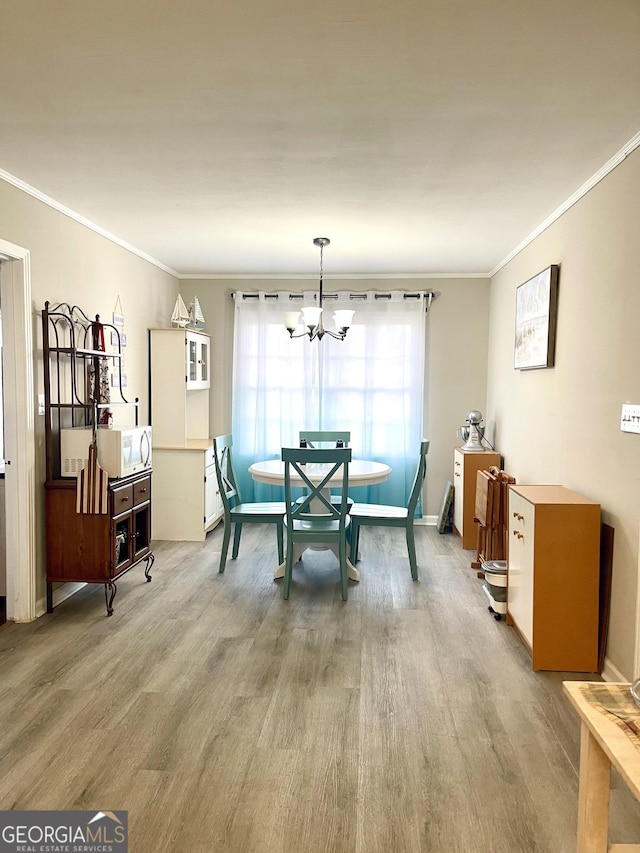 dining room featuring a chandelier, light hardwood / wood-style floors, and ornamental molding