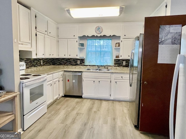 kitchen with white cabinets, appliances with stainless steel finishes, light hardwood / wood-style floors, and sink