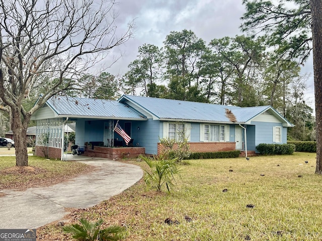 ranch-style house featuring a front lawn and a carport