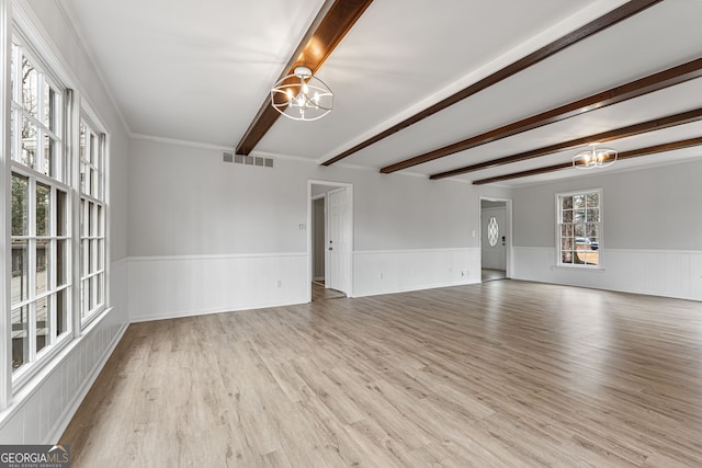 unfurnished room with beam ceiling, light hardwood / wood-style flooring, and a notable chandelier