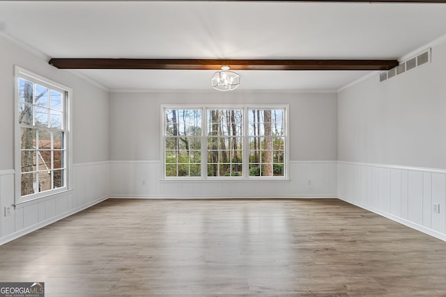 spare room featuring hardwood / wood-style floors, plenty of natural light, beamed ceiling, and a chandelier