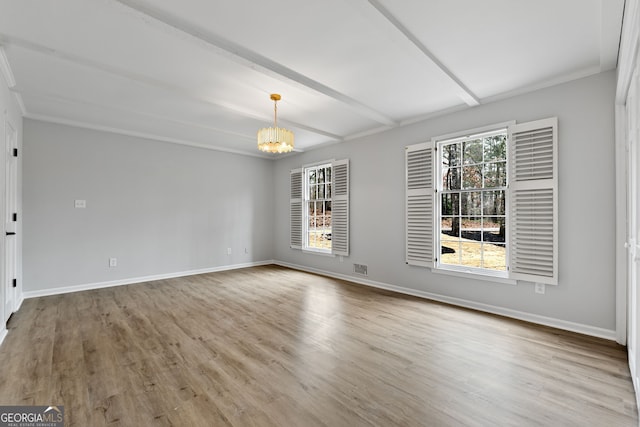 spare room featuring a chandelier, light wood-type flooring, and beamed ceiling