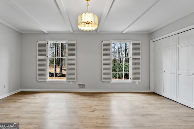 unfurnished dining area with beam ceiling, light wood-type flooring, and a chandelier