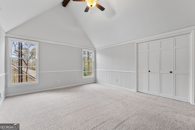 unfurnished bedroom with carpet flooring, ceiling fan, and lofted ceiling with beams