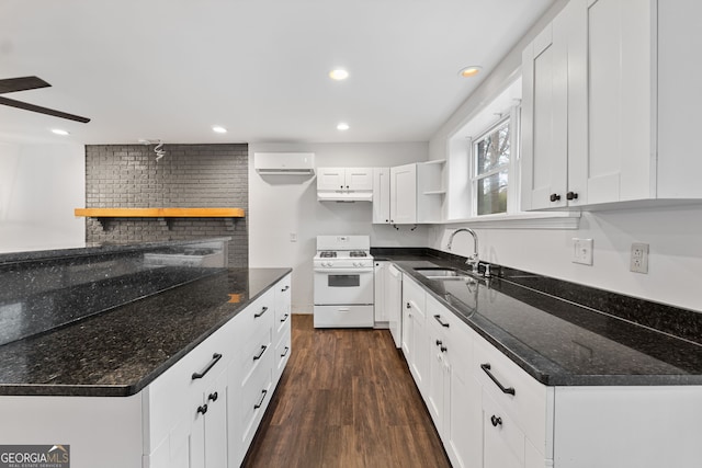 kitchen featuring sink, dark hardwood / wood-style floors, dark stone countertops, white cabinets, and white stove