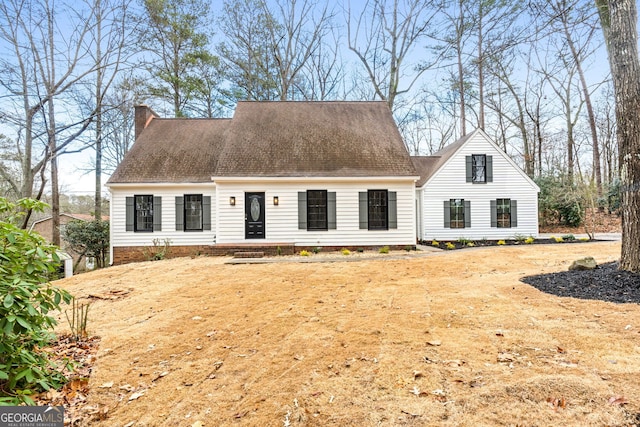 cape cod house featuring a front lawn