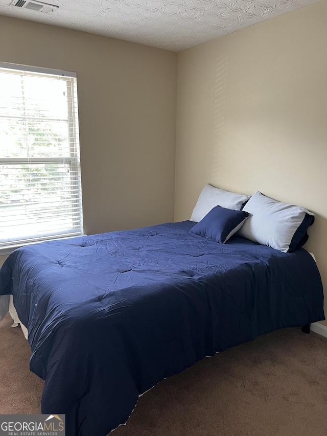 carpeted bedroom with a textured ceiling