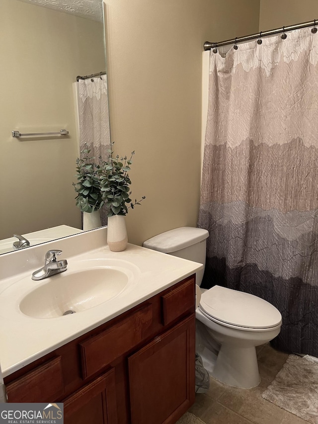 bathroom with tile patterned floors, vanity, and toilet