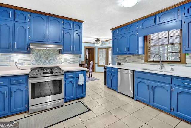 kitchen with appliances with stainless steel finishes, blue cabinets, ceiling fan, sink, and light tile patterned flooring