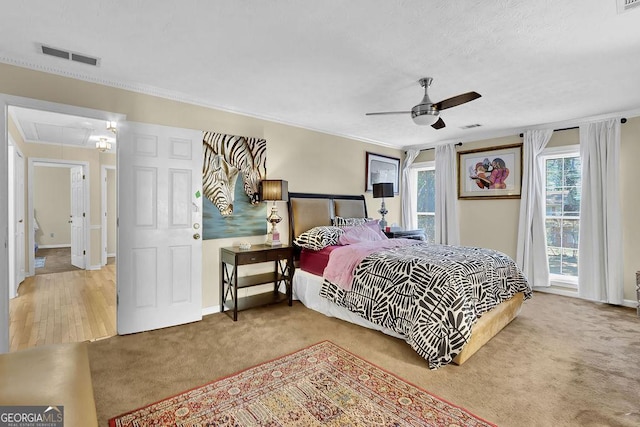 bedroom featuring ceiling fan, carpet floors, and ornamental molding