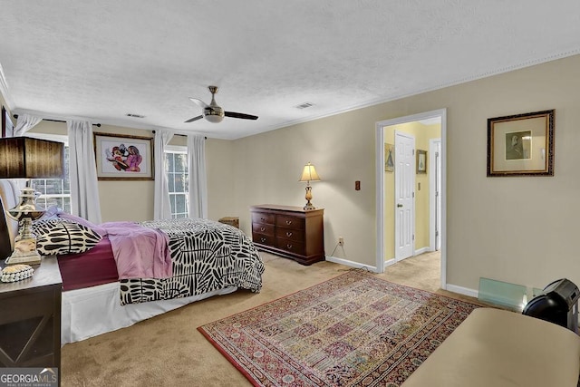 carpeted bedroom featuring ceiling fan and a textured ceiling