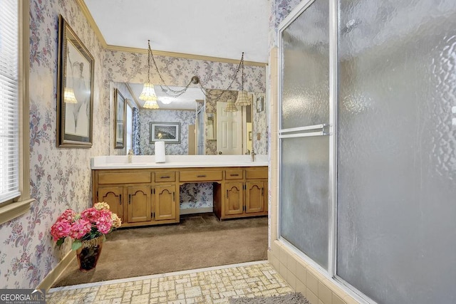 bathroom featuring a shower with door, vanity, and ornamental molding