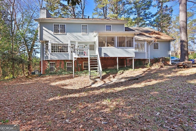 rear view of house featuring a sunroom