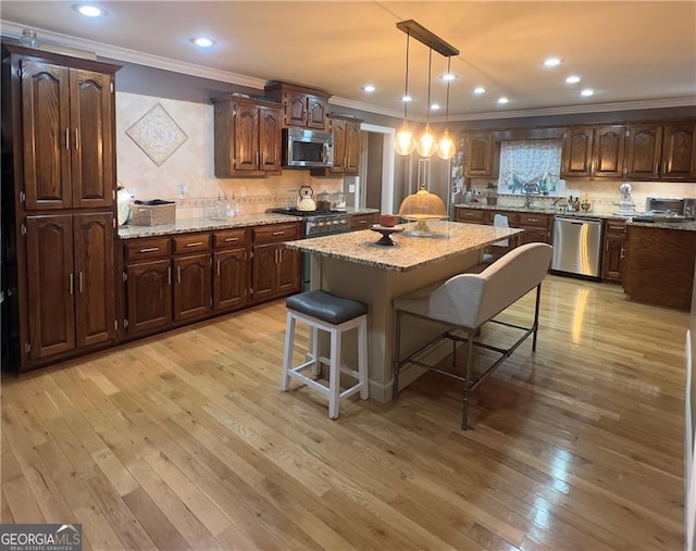 kitchen featuring decorative backsplash, a center island, stainless steel appliances, and light stone counters