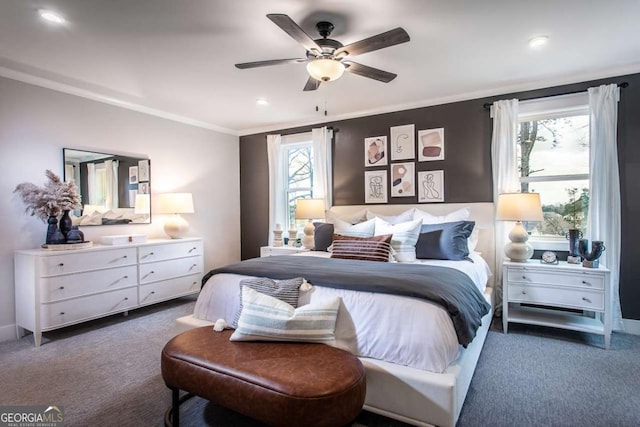 bedroom with dark colored carpet, ceiling fan, crown molding, and multiple windows