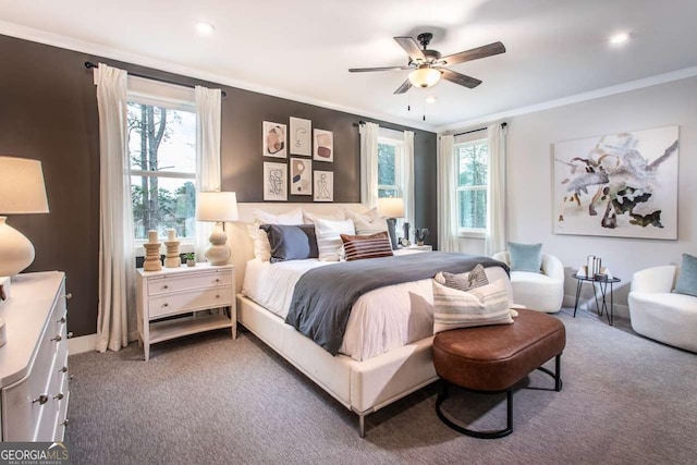 bedroom featuring ceiling fan, ornamental molding, carpet floors, and multiple windows