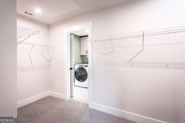 laundry area featuring cabinets, washer / dryer, and carpet flooring