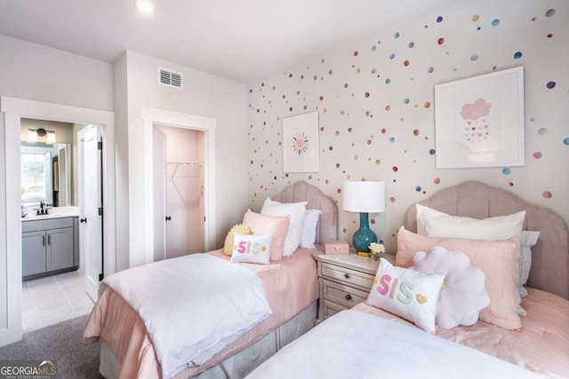 tiled bedroom with connected bathroom, a spacious closet, and a closet