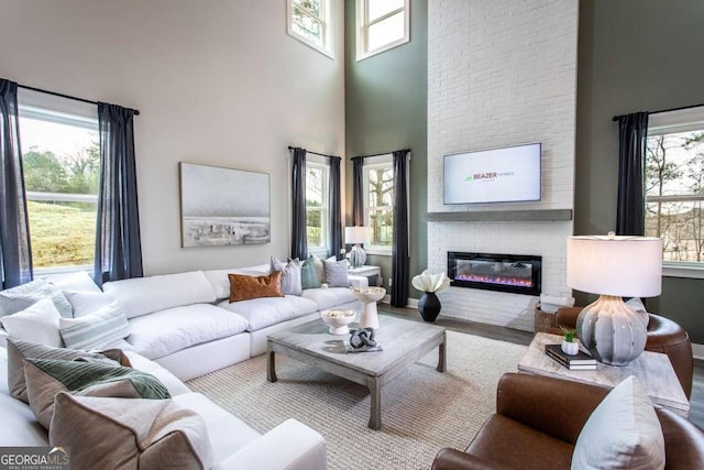 living room with a high ceiling and a brick fireplace