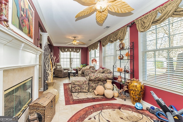 living room with decorative columns, ceiling fan, a fireplace, and ornamental molding