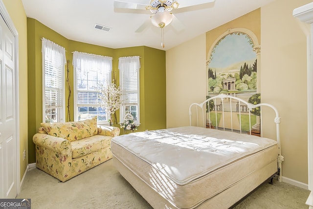 bedroom featuring a closet, light colored carpet, and ceiling fan