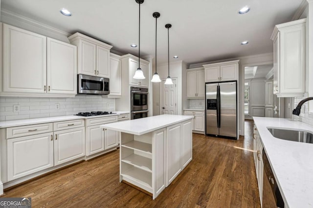 kitchen featuring stainless steel appliances, sink, white cabinetry, a kitchen island, and hanging light fixtures