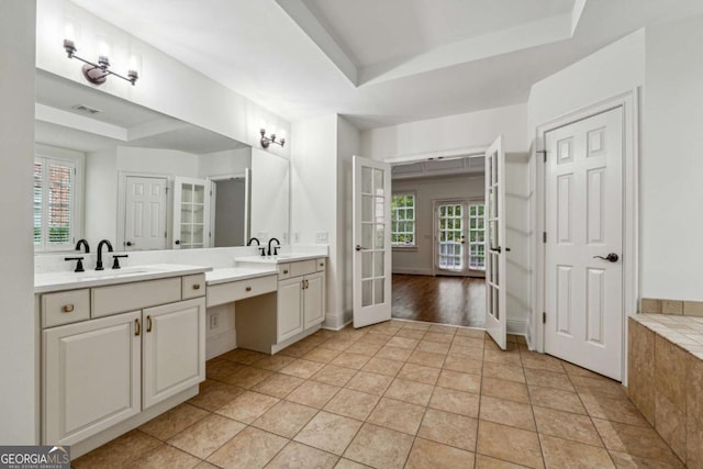 bathroom with a raised ceiling, tile patterned flooring, and french doors