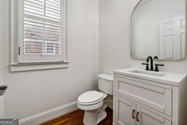 bathroom with hardwood / wood-style flooring, vanity, and toilet