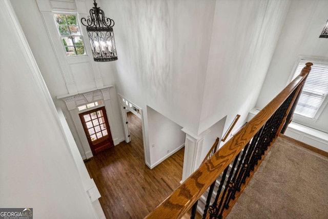 carpeted entryway featuring a chandelier and a high ceiling