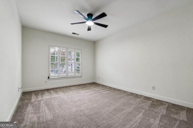 carpeted spare room featuring ceiling fan