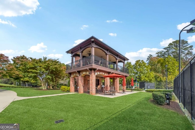 rear view of house with a patio area, ceiling fan, and a yard