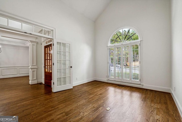 empty room with lofted ceiling, dark wood-type flooring, and french doors