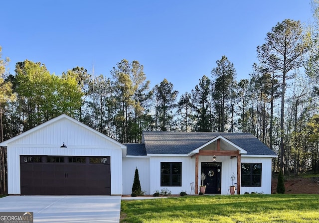 modern farmhouse featuring a garage and a front lawn