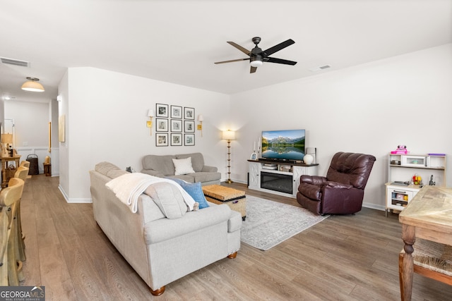 living room with ceiling fan and wood-type flooring