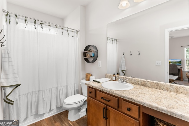 full bathroom with toilet, vanity, hardwood / wood-style flooring, and shower / tub combo with curtain