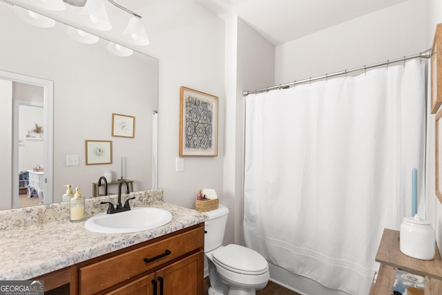 bathroom with curtained shower, vanity, and toilet