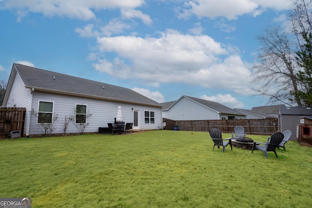 back of house featuring a yard and an outdoor fire pit