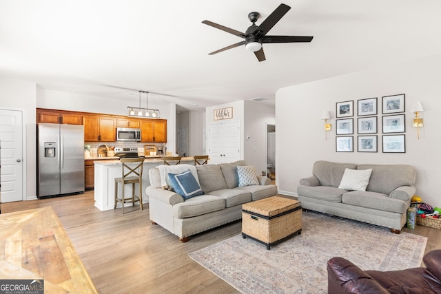 living room with ceiling fan and light hardwood / wood-style floors