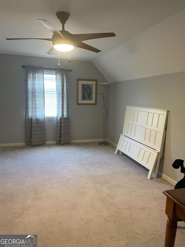 interior space with light carpet, vaulted ceiling, and ceiling fan