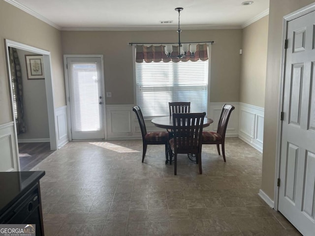 dining area with crown molding and a chandelier