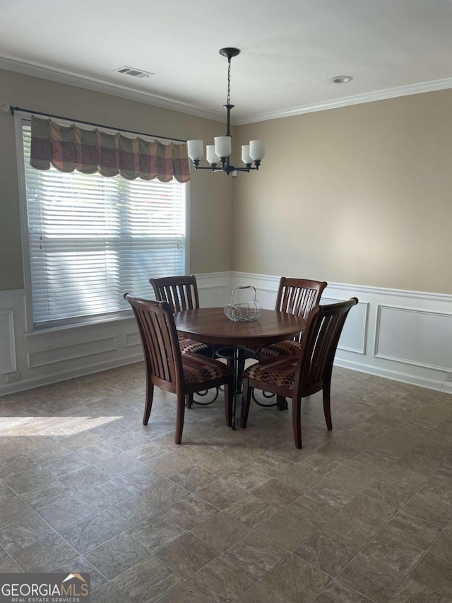 dining area featuring crown molding and a notable chandelier