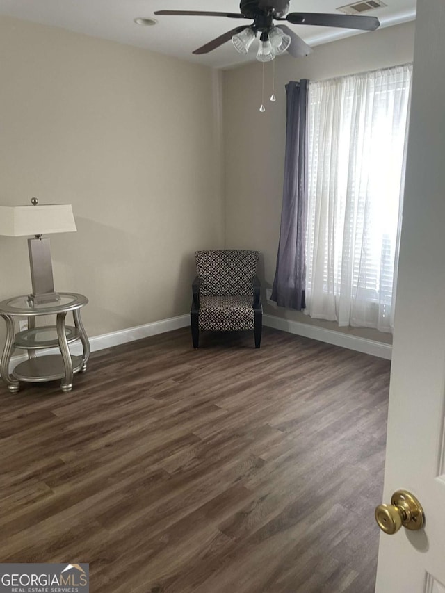 living area featuring ceiling fan, plenty of natural light, and dark hardwood / wood-style floors