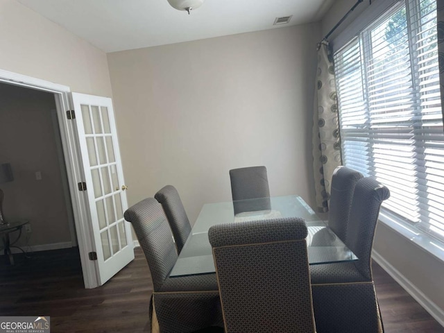 dining space with dark hardwood / wood-style flooring and a healthy amount of sunlight