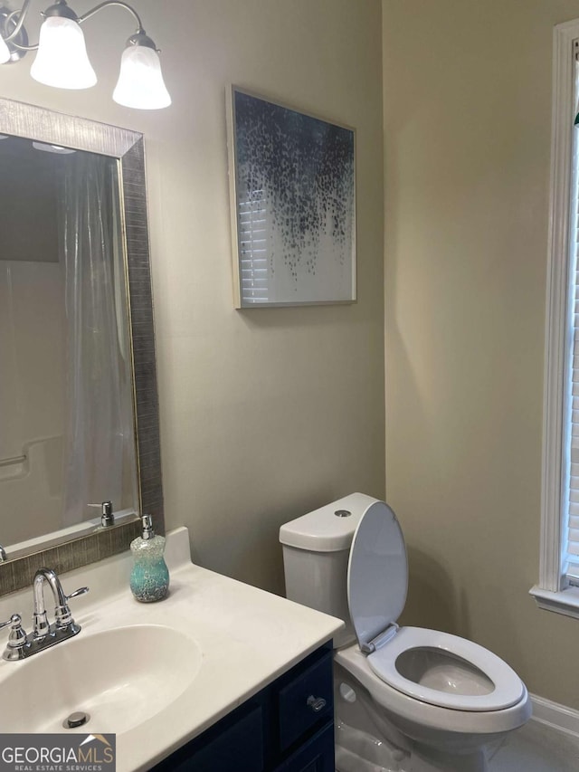 bathroom featuring vanity, toilet, and curtained shower